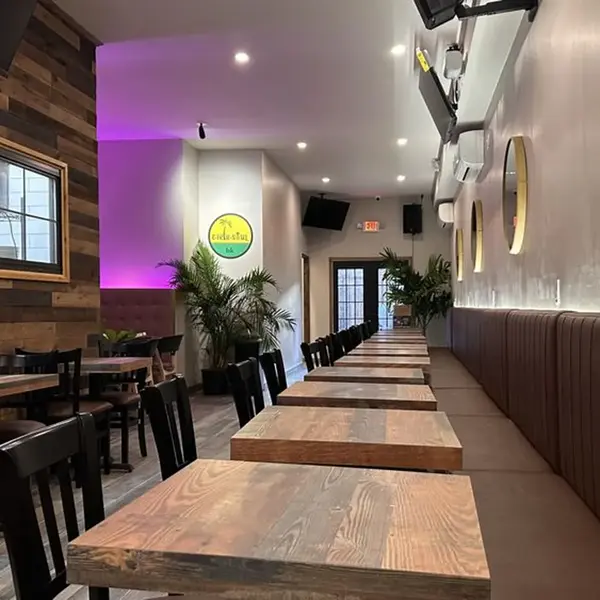 Main room at Carib Soul BK with porthole mirrors and the long communal bar