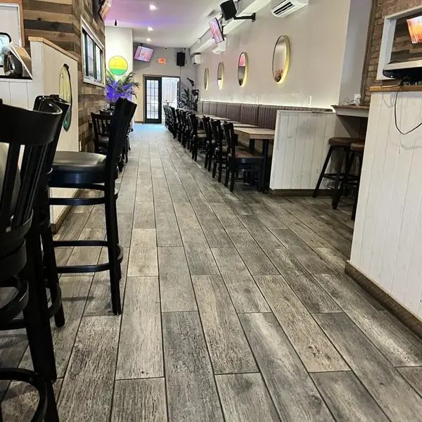 Carib Soul BK dining room with long wooden tables and the round logo on the back wall