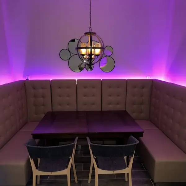 Purple-lit lounge booth with a sphere chandelier at Carib Soul BK